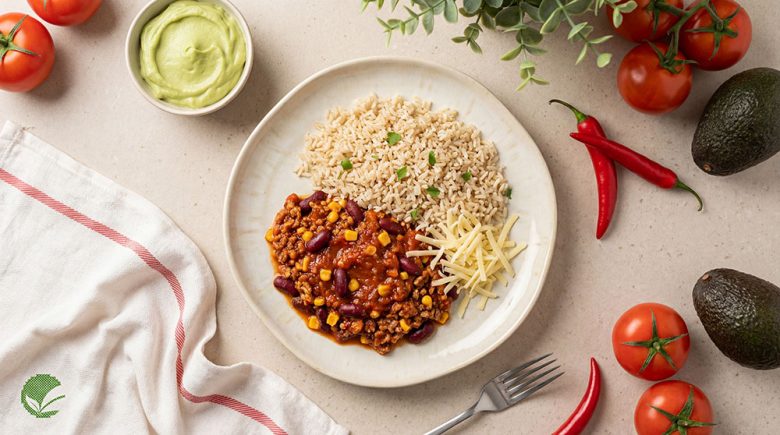 Chilli sin carne z roślinnym mięsem, czerwoną fasolą i kukurydzą, z brązowym ryżem i musem z awokado