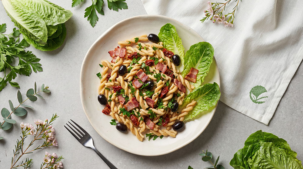 Białkowe świderki alla carbonara z sałatą rzymską, suszonymi pomidorami i oliwkami